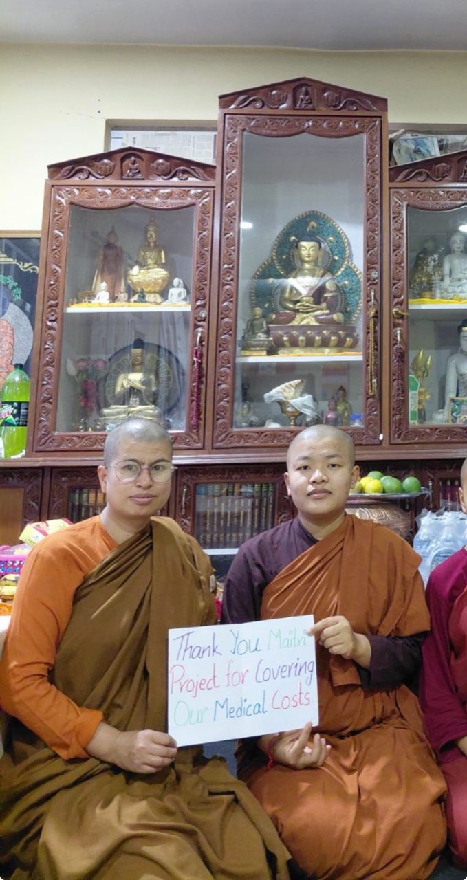 Two monastics thanking Maitri for covering medical costs