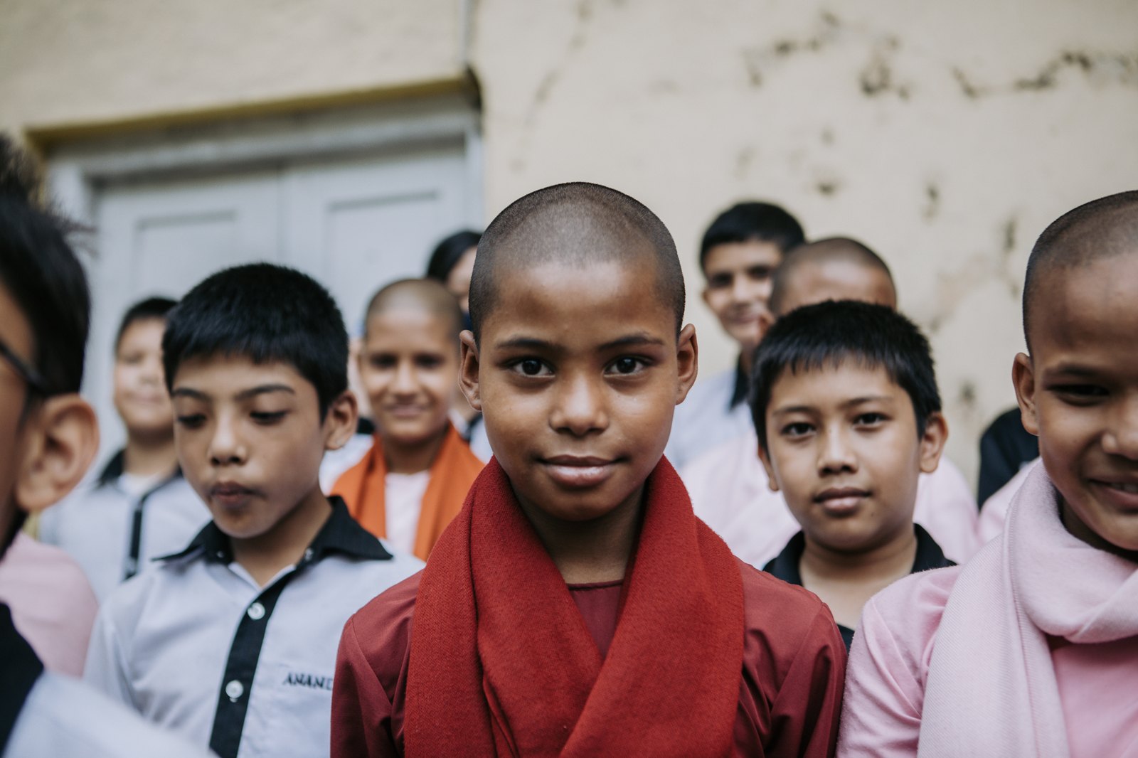 A young novice looking directly at the camera, classmates behind